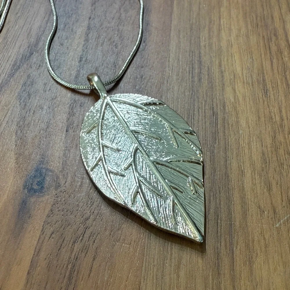 Aldo Gold Tone Clear Rhinestone Long Necklace with Leaf Feather Pendant